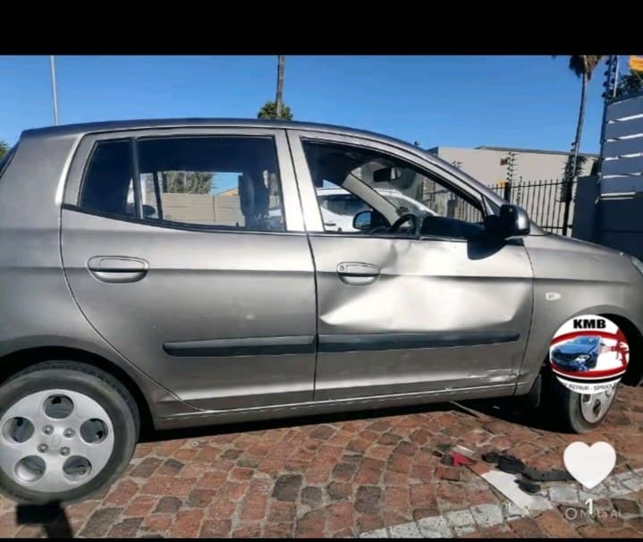 Grey hatchback with side damage in for repair