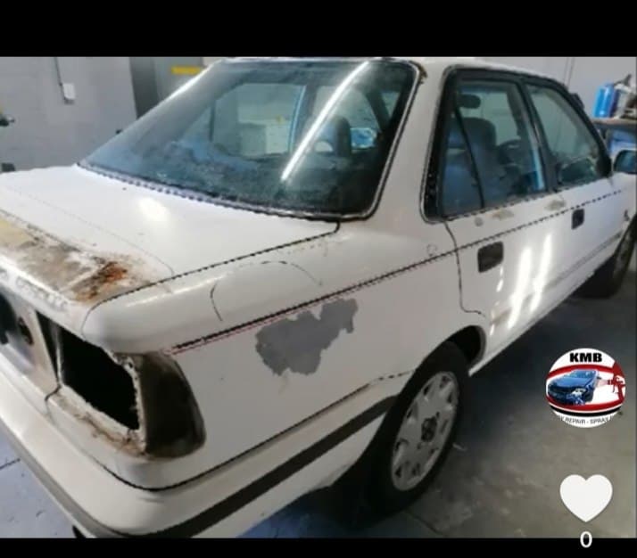 White sedan with rust being repaired at KMB